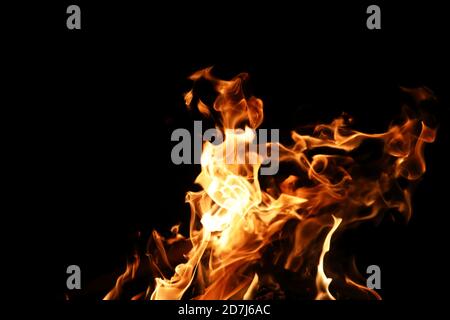 Lingue di fiamma di fuoco di colore giallo-arancio dalla combustione legna da ardere Foto Stock