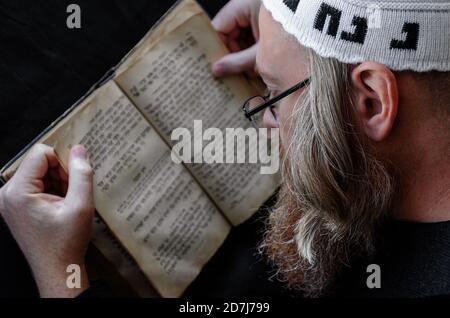 L'ebreo Chassidico legge Siddur. Ebreo ortodosso religioso con barba rossa e con ritmo in balla bianca in preghiera. Primo piano Foto Stock