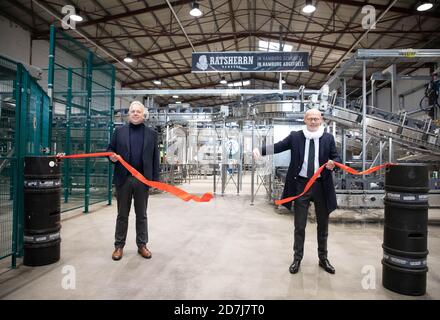 Amburgo, Germania. 23 Ott 2020. Michael Westhagemann (non partisan, r), senatore per l'economia, i trasporti e l'innovazione ad Amburgo, e Oliver Nordmann, Managing Partner della fabbrica di birra Ratsherrn, ha tagliato un nastro rosso durante la cerimonia di inaugurazione del nuovo impianto di imbottigliamento della fabbrica di birra Ratsherrn di Amburgo. Venerdì, la fabbrica di birra Ratsherrn ha inaugurato il proprio impianto di imbottigliamento ad Amburgo. Westhagemann indossa una ruffa del collo degli aldermen che ha ricevuto come dono dalla fabbrica di birra. Credit: Christian Charisius/dpa/Alamy Live News Foto Stock