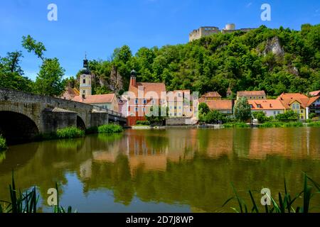 Germania, Baviera, Kallmunz, ponte ad arco sul fiume Naab e case in riva al fiume in estate Foto Stock