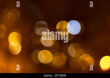 Bokeh arancione di luci della città su sfondo arancione scuro. Foto Stock