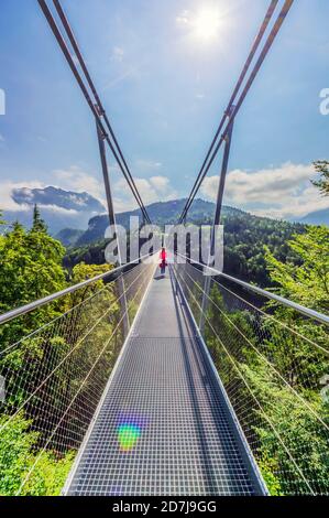 Austria, Tirolo, Reutte, Donna in piedi nel mezzo di Highline179 in giornata di sole Foto Stock