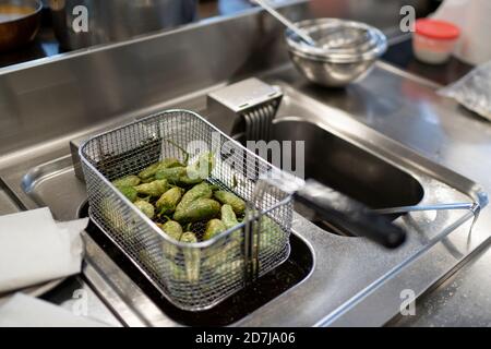 Peperoni Jalapeno in cestino su friggitrice in cucina commerciale Foto Stock