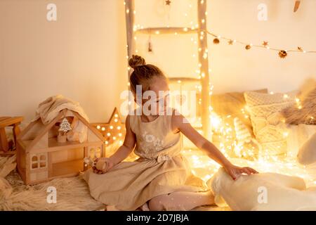 Bambina che gioca con orsacchiotto in camera durante il natale Foto Stock