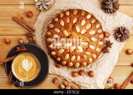 Torta fatta in casa con mandorle e tazza di cappuccino al caffè su un tavolo di legno. Vista dall'alto. Foto Stock