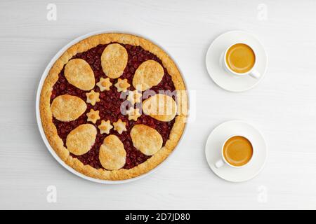 Torta di ciliegia frolla fatta in casa e due tazze bianche di caffè espresso su tavolo di legno bianco. Vista dall'alto. Foto Stock