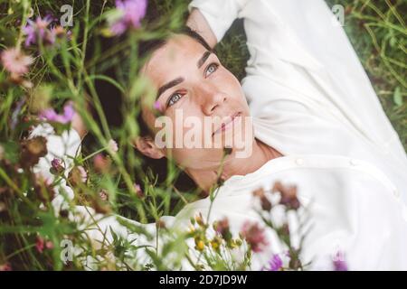 Donna premurosa che guarda via mentre si sdraia sulla terra Foto Stock