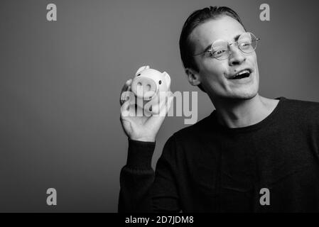 Giovane bell'uomo che indossa una camicia a maniche lunghe su sfondo grigio Foto Stock