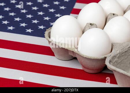 Cartone di uova bianche sulla bandiera degli Stati Uniti d'America. Concetto di allevamento avicolo, industria e produzione di uova Foto Stock