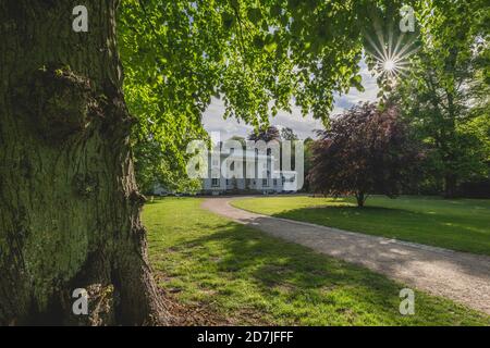 Germania, Amburgo, alberi e sentieri con edificio bianco in Hirschpark Foto Stock