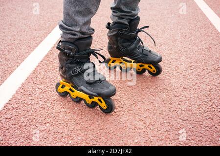 Uomo con pattini in linea in piedi sul ponte in città Foto Stock