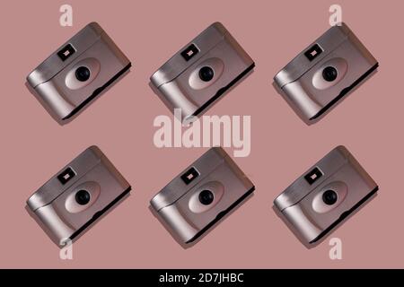 Primo piano di telecamere disposte su sfondo rosa Foto Stock