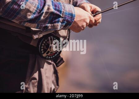 Primo piano di pescatore che legano canna da pesca sulla vita Foto Stock