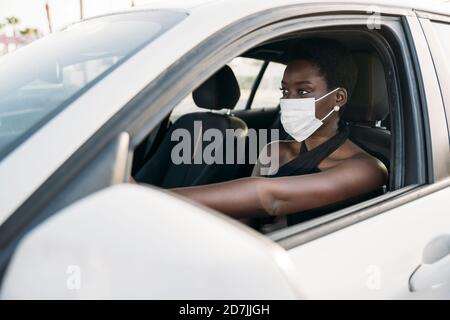 Giovane donna con maschera di guida auto Foto Stock