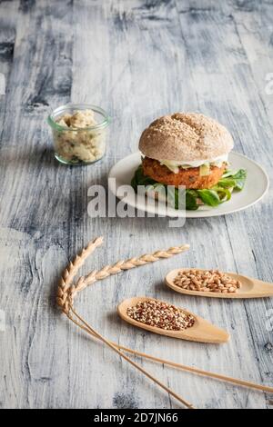 Hamburger vegetariano e due cucchiai di legno con farro grunkern e. quinoa Foto Stock