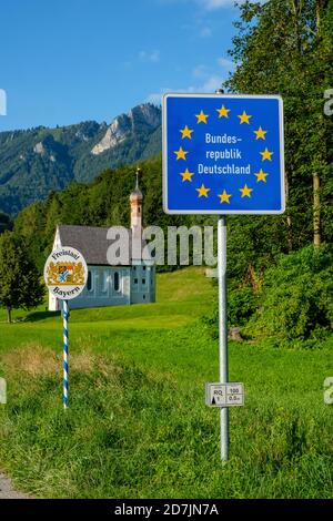Germania, Baviera, Nussdorf, cartello di stato con sullo sfondo Kreuzkirche Foto Stock