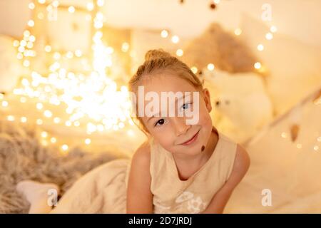 Bambina sorridente mentre si siede in camera durante natale Foto Stock