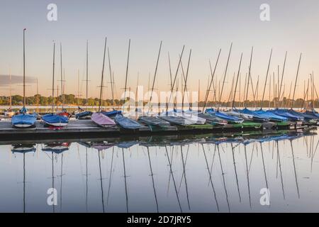 Germania, Amburgo, fila di barche a vela ormeggiate sul lago Outer Alster al tramonto Foto Stock