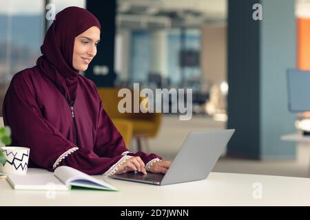 Giovani arabi business donna indossa hijab,lavorando nel suo ufficio di avvio. La diversità, multirazziale concept Foto Stock