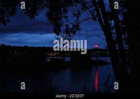 Lanterna rossa di segnalazione nel punto esatto in cui il fiume meno sta allagando nel fiume Rhein al Mainspitze in Magonza, Germania durante la notte Foto Stock