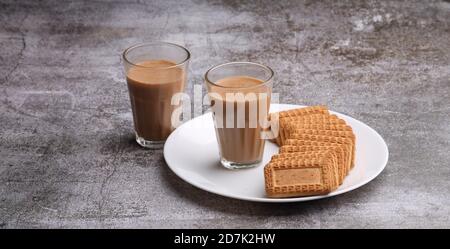 Chai taglio, tradizionale Desi Roadside tè dell'india con biscotti. Foto Stock