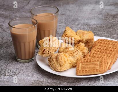 taglio chai masala o tè servito con pasta sfoglia / khari e biscotti. Foto Stock