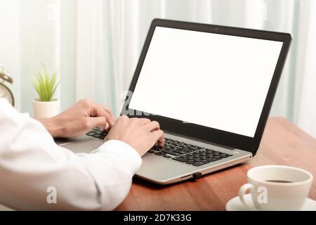 Uomo d'affari che lavora su un computer portatile a casa mentre è seduto Il tavolo di legno.mani maschili che digitano sulla tastiera del notebook.acquisti online,lavoro da Foto Stock