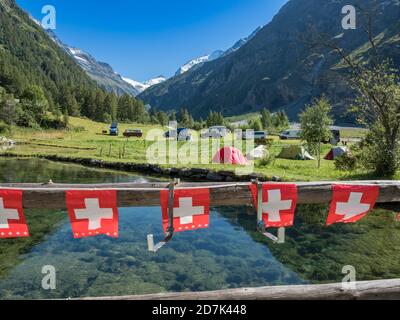 Tende e camper su un piccolo campeggio, villaggio Zinal, catena montuosa nella parte posteriore, Val d'Anniviers, Svizzera Foto Stock