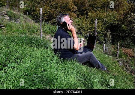 L'uomo d'affari è al telefono in un naturale ambiente Foto Stock