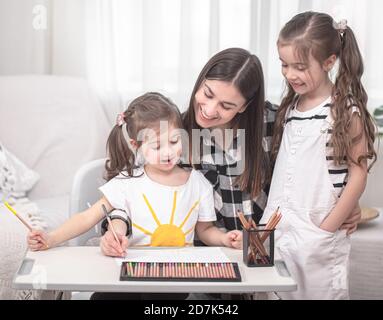 Madre con i bambini seduti al tavolo e facendo i compiti. Il bambino impara a casa. Scuola domestica. Spazio per il testo. Foto Stock