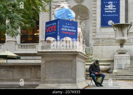 La Biblioteca pubblica di New York leoni, pazienza e fortezza, indossare maschere e incoraggiare le persone a votare il 23 ottobre 2020 a New York. Foto Stock