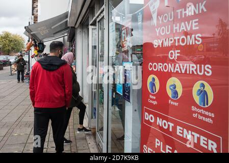 Slough, Regno Unito. 23 ottobre 2020. Gli acquirenti indossano rivestimenti per il viso per prevenire la diffusione del coronavirus. Il governo ha annunciato che Slough cambierà il suo status di livello di allarme COVID da livello 1 Medio Alert a livello 2 High Alert con effetto dalle 00:01 di sabato 24 ottobre, a seguito di un aumento sostenuto dei casi COVID-19, con conseguente tasso di infezione di 153 casi ogni 100,000. Credit: Mark Kerrison/Alamy Live News Foto Stock