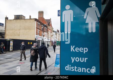 Slough, Regno Unito. 23 ottobre 2020. Un'esposizione pubblica di informazioni del Consiglio di Slough Borough ricorda ai residenti locali di osservare le distanze sociali per aiutare a prevenire la diffusione del coronavirus. Il governo ha annunciato che Slough cambierà il suo status di livello di allarme COVID da livello 1 Medio Alert a livello 2 High Alert con effetto dalle 00:01 di sabato 24 ottobre, a seguito di un aumento sostenuto dei casi COVID-19, con conseguente tasso di infezione di 153 casi ogni 100,000. Credit: Mark Kerrison/Alamy Live News Foto Stock