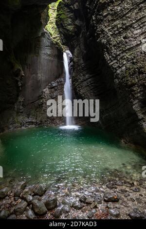Srap Kozjak cascata che emerge in grotta piscina vicino Kobarid, Slovenia Foto Stock