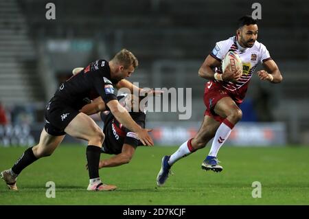 Il francese Bevan dei guerrieri di Wigan (a destra) si rompe da Joey Lussick di Salford Red Devils (a sinistra) e Kallum Watkins durante la partita della Betfred Super League al Totally Wicked Stadium, St Helens. Foto Stock