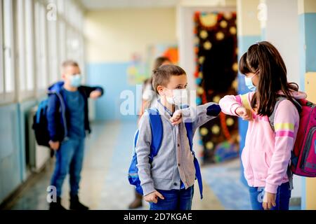 Gli studenti elementari si salutano con il gomito Foto Stock