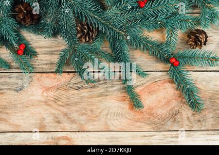 Rami di un albero di Natale su sfondo ligneo con coni, bacche di Rowan con spazio copia, vista dall'alto. Spazio per la copia di Natale e Capodanno. Foto Stock