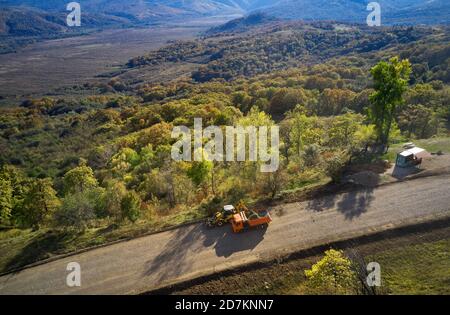 Almaty, Kazakhstan - 13 maggio 2019 - i lavoratori della strada stanno dipingendo la linea bianca sulla strada di montagna. Coni stradali con strisce rosse e gialle sullo sfondo, stand Foto Stock