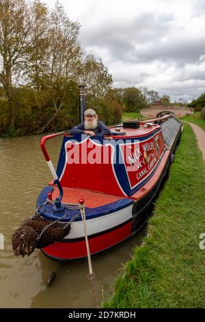 proprietario della barca tradizionale lavoratore di canale su una barca stretta funzionante o chiatta sul canale a braunston nel northamptonshire, regno unito Foto Stock