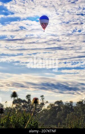 Mongolfiera alta nel cielo vicino Dubbo città ON Pianure Australiane Great Western nel NSW - soft mattina sole leggero Foto Stock
