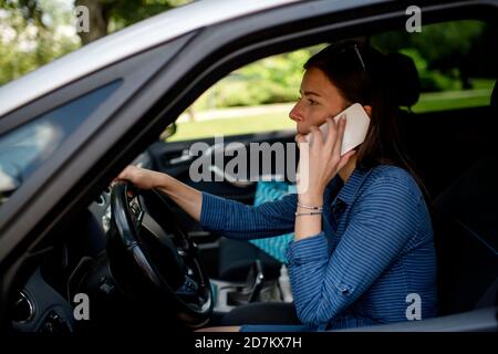 Donna in maschera protettiva che guida un'auto Foto Stock