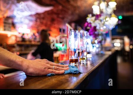 Warendorf, Germania. 23 Ott 2020. Poco prima dell'orario di chiusura, una cameriera pulisce il bancone del Warendorf Bar n.1 accanto a due bicchieri di birra vuoti. Nella Renania settentrionale-Vestfalia è stato introdotto un coprifuoco obbligatorio tra le 11 e le 6 del mattino per i ristoranti di tutte le comunità con un elevato numero di nuove infezioni da corona. Il coprifuoco si applica nei comuni con 50 o più nuove infezioni ogni 100,000 abitanti entro sette giorni. Credit: Guido Kirchner/dpa/Alamy Live News Foto Stock