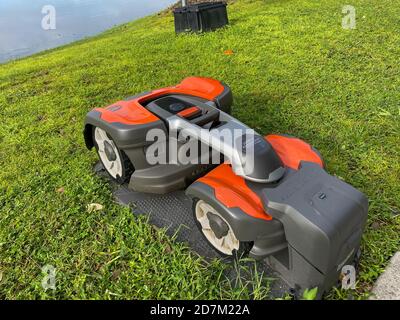 Orlando, FL./USA - 9/30/20: Un rasaerba autonomo Husqvarna attraccato su una stazione di ricarica nel quartiere di Laureate Park a Orlando, Florida Foto Stock