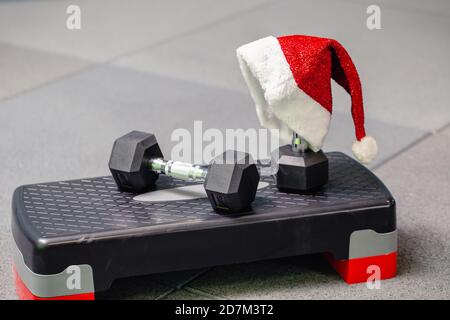 Cappello di Babbo Natale in palestra. Concetto di sport su Natale e Capodanno. Concetto di fitness, stile di vita sano e attivo. Foto Stock