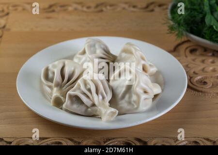 Gnocchi georgiani Khinkali con carne. Khinkali in un piatto bianco. Foto Stock