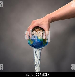 Spremere l'acqua dalla terra Foto Stock