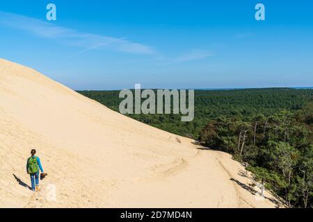 Donna singola che scende dalla Dune du Pilat in Francia occidentale Foto Stock