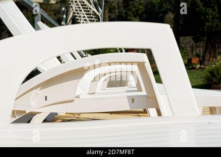 Primo piano delle maniglie delle sedie da spiaggia in plastica bianca Foto Stock