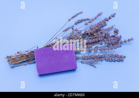 Lavanda sapone naturale fatto a mano con fiore di lavanda su sfondo blu Foto Stock