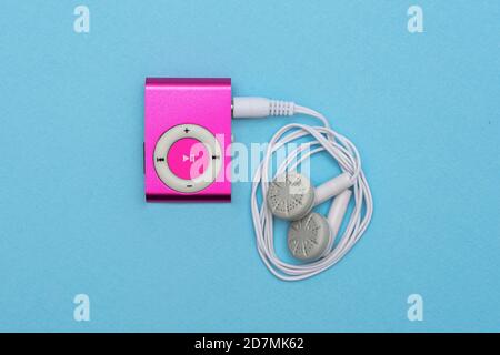 Lettore MP3 Digital Pink con cuffie su sfondo blu Foto Stock